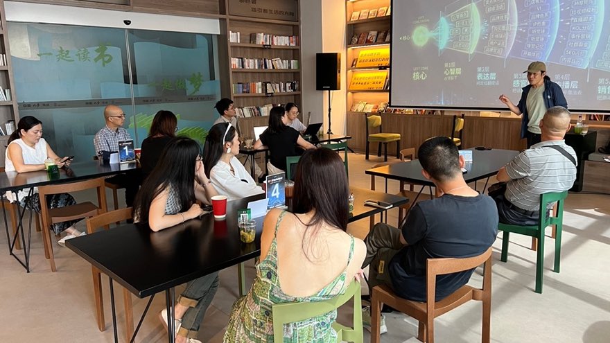 学员围坐听讲，讲师演示品牌战略层级